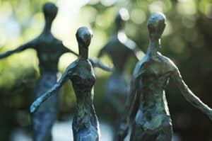 Silhouette inspired metal sculptures on display with park behind them