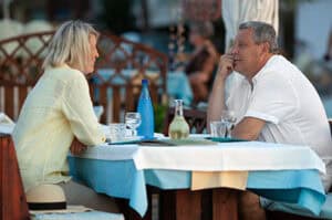Older couple talking over drinks at an outdoor restaurant