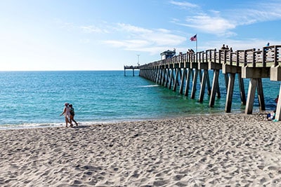 People walking on Venice Beach next to the Venice Pier