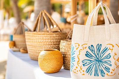 Table displaying woven baskets and canvas totes
