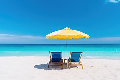 Two blue beach chairs sitting under a yellow umbrella on Siesta Key Beach